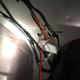 Shoving the camera’s two wires into the connector for the lights on the rear of the car to test whether the camera actually works before we continue installing it.